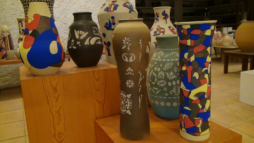 diversitat de peces, algunes amb representacions pictòriques abstractes de color, altres blanques sobre fons fosc