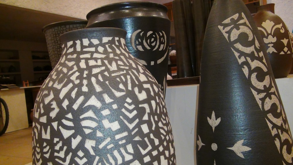 detall de tres ceràmiques de color fosc amb pintures abstractes de color blanc